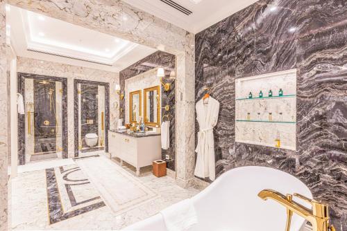 a bathroom with a tub and a marble wall at Wellness Park Hotel Bactria in Samarkand