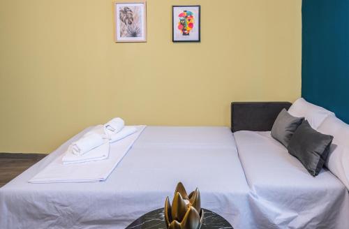a bedroom with a white bed with two towels on it at Hara Apartments in Chrysoupolis