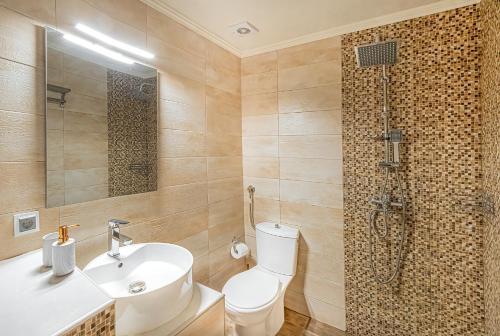 a bathroom with a toilet and a sink and a shower at Hara Apartments in Chrysoupolis