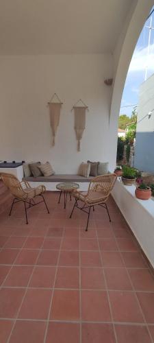 a patio with two chairs and a table and a couch at Oros Eros in Hydra