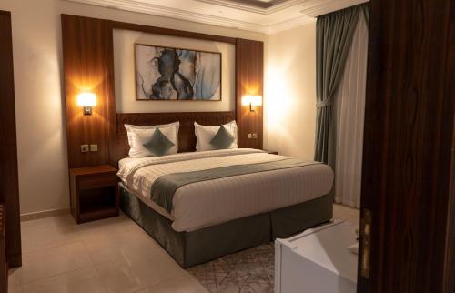 a hotel room with a large bed with two lights at Ramz Al Diyafa 1 in Taif