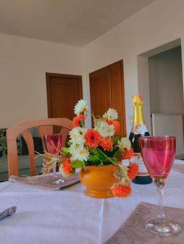 a table with a vase of flowers and a wine glass at Serenity's Sunset Terrace in Shkodër