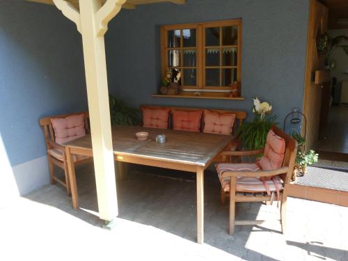einen Holztisch und Stühle auf einer Terrasse in der Unterkunft Privatzimmer Rethaber in Ringsheim