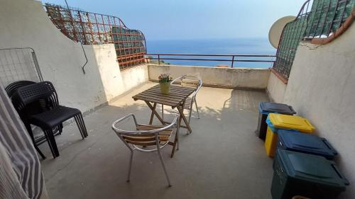 einen Balkon mit einem Tisch, Stühlen und Meerblick in der Unterkunft Casa Lucia in Letojanni