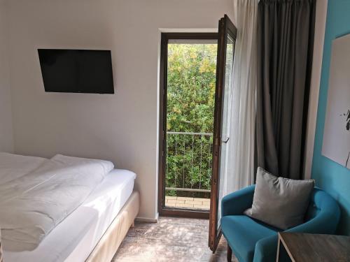 - une chambre avec un lit, une chaise et une fenêtre dans l'établissement Akteon Hotel, à Stuttgart