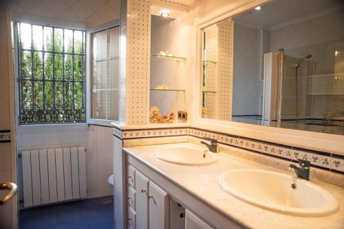 a bathroom with two sinks and a large mirror at Villa del Mamut, Padul Granada in Padul