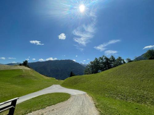 a dirt road in the middle of a grassy hill at Ferienwohnung Praißkopf Blick in Pfunds