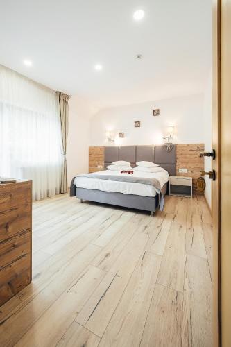 a bedroom with a bed and a wooden floor at Blumenhof Bucovina in Voronet