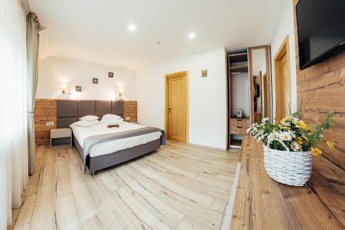 a bedroom with a bed and a television in it at Blumenhof Bucovina in Voronet