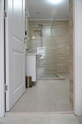eine offene Tür zu einem Zimmer mit Bad in der Unterkunft Vila Exclusive in Târgu Jiu