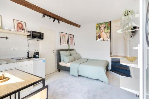 a white room with a bed and a kitchen at Tiny apartment with spacious terrace on the Rhine in Neuwied