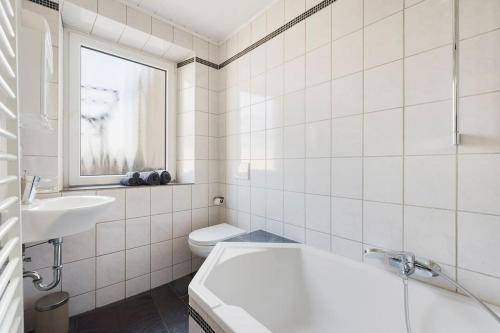 a white bathroom with a sink and a toilet at Tiny apartment with spacious terrace on the Rhine in Neuwied