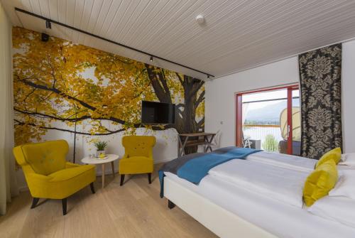 1 dormitorio con 1 cama grande y un mural de árboles en Kleines Hotel Kärnten, en Egg am Faaker See