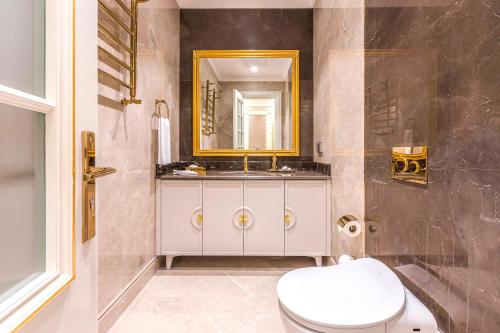 a bathroom with a white toilet and a mirror at Wellness Park Hotel Turon in Samarkand