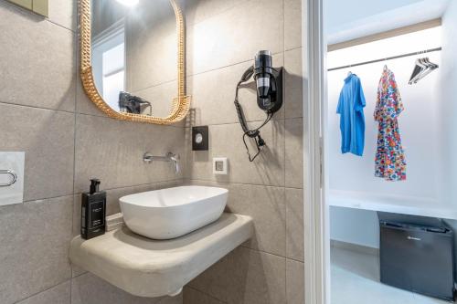 bagno con lavandino bianco e specchio di ALIRENE MYKONOS a Panormos - Mykonos
