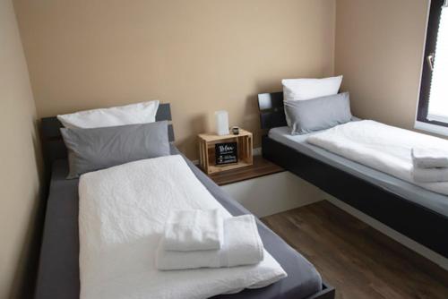 2 camas individuales en una habitación con ventana en B&B Malú am Ring, en Müllenbach