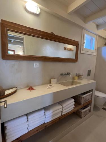 W łazience znajduje się umywalka, lustro i ręczniki. w obiekcie Villa Margarita w mieście Samos