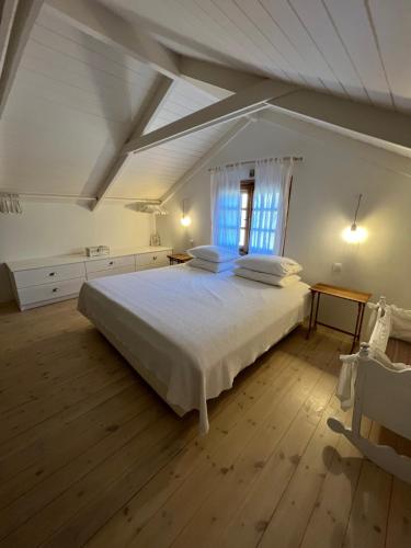 Un dormitorio con una gran cama blanca y una ventana en Villa Margarita en Samos
