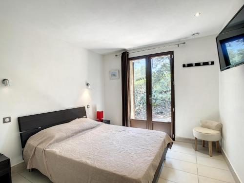 une chambre blanche avec un lit et une fenêtre dans l'établissement La Petite Bergerie, au Plan-de-la-Tour