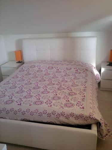アルゲーロにあるCasa vacanze Algheroのベッドルーム1室(ピンクの毛布付きのベッド1台付)