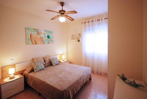 a bedroom with a bed and a ceiling fan at La Adela in Denia