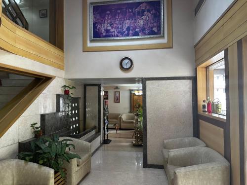 a hallway with couches and a painting on the wall at Hotel Ashirwad in Pune