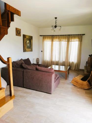 a living room with a couch and a table at κτήμα ΝΟΣΤΟΣ in Aígio