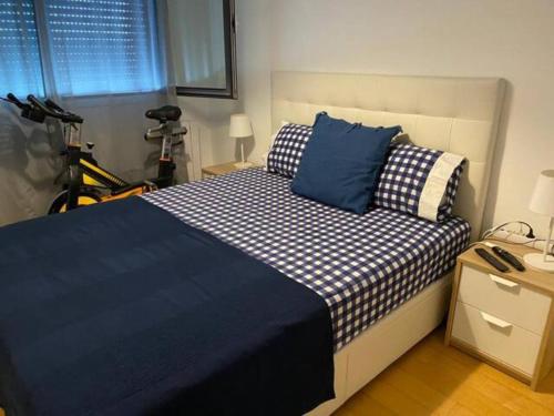 1 dormitorio con 1 cama con sábanas azules y blancas en Lisboa Deluxe Apartment - Parque das Nações, en Lisboa