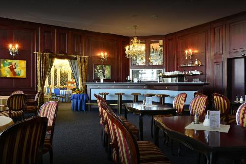 a restaurant with tables and chairs and a bar at Hotel Olympik in Prague