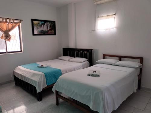 two beds sitting in a room withermottermottermott at Hotel Las Vegas by CMS hotels in Santa Marta