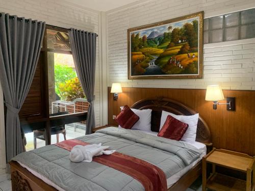 a bedroom with a bed with a stuffed animal on it at Dewa Bharata Bungalows Ubud in Ubud