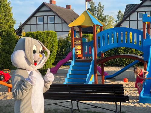 a person dressed in a bunny costume standing in front of a playground at Morska Kraina in Białogóra