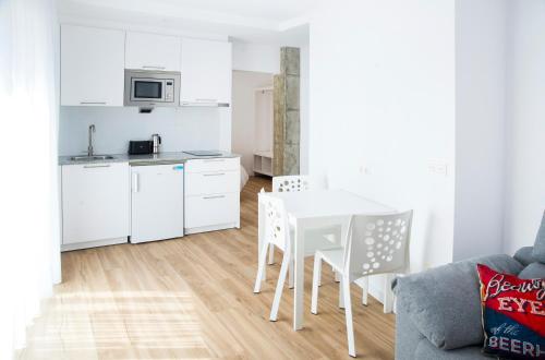 a kitchen and dining room with a white table and chairs at P1 O Grove centro puerto in O Grove