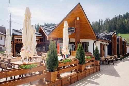 een restaurant met tafels en gesloten parasols bij Blumenhof Bucovina in Voronet