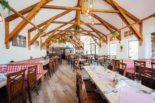 a dining room with wooden tables and chairs at Blumenhof Bucovina in Voronet