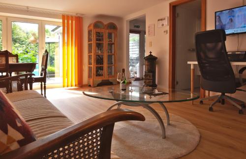 a living room with a glass table and a couch at Ferienwohnung An den Linden in Kelmis