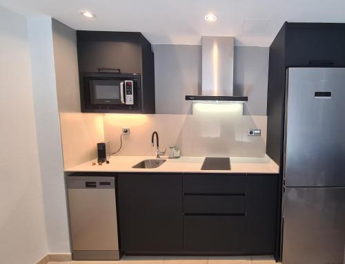 a kitchen with a sink and a refrigerator at OLGAPARTMENT in Miami Platja