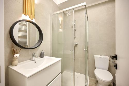 a bathroom with a sink and a toilet and a mirror at Smarald Sea View Apartment in Infinity Beach Resort - parking in Mamaia