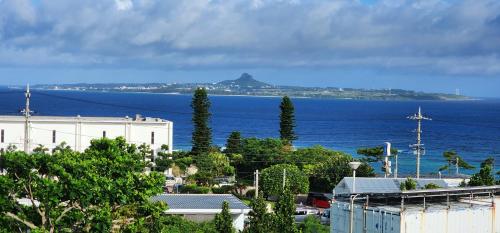 a view of the ocean and a city with trees at ザ・ヴィラス待遠屋 in Bise