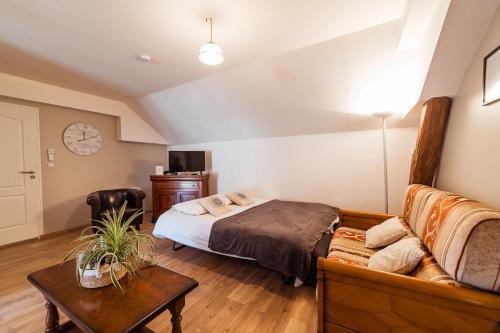 ein Schlafzimmer mit einem Bett und einem Sofa in der Unterkunft Maison Calme 14 personnes, piscine, jardin et parking in Buchères
