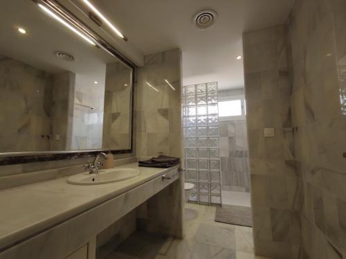 a bathroom with a sink and a mirror and a shower at Room near the sea in Marbella