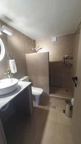 La salle de bains est pourvue de toilettes blanches et d'un lavabo. dans l'établissement AQUA VILLA, à Selínia