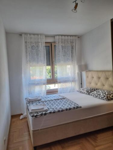 een slaapkamer met een groot bed en een raam bij Apartman Bruna in Zagreb