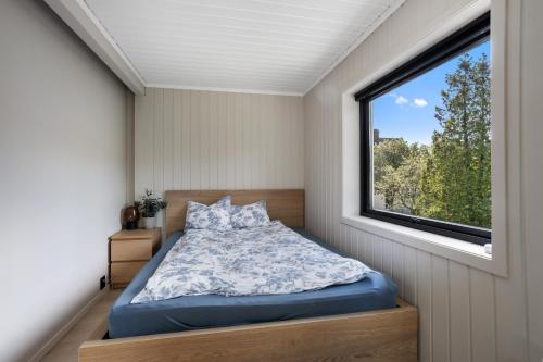 a bedroom with a bed and a window at 2 Bedroom apartment w/ Parking & Balcony in Tønsberg