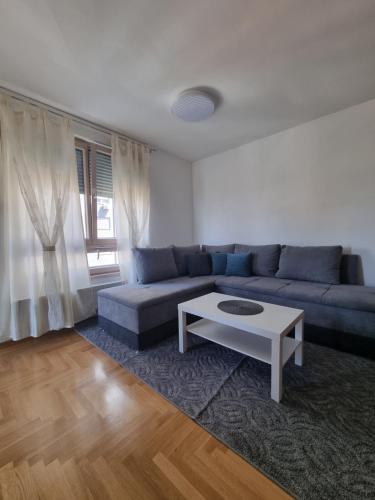 a living room with a blue couch and a coffee table at Apartman Bruna in Zagreb
