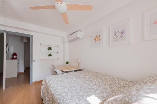 een slaapkamer met een bed en een plafondventilator bij Living Caja Mágica in Madrid