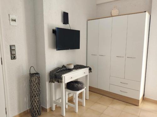 a room with a desk and a tv on a wall at Kyrva Bay Studios in Ierápetra