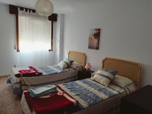 a bedroom with two beds and a window at Vivienda 2 sin ascensor in Laxe