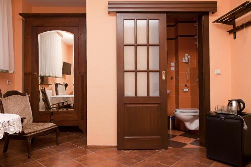 a bathroom with a toilet and a door with a mirror at Dom wczasowy HEEP in Białogóra