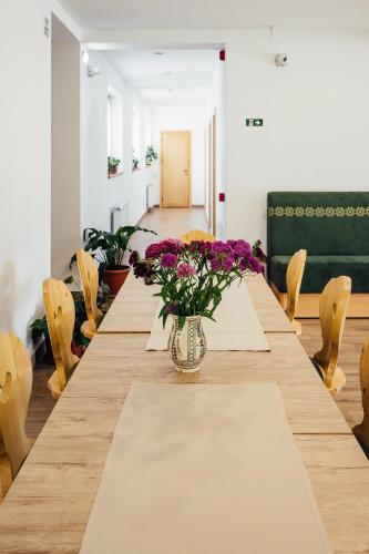 a long table with purple flowers in a vase on it at Blumenhof Bucovina in Voronet